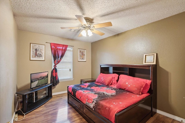 bedroom featuring ceiling fan, a textured ceiling, and hardwood / wood-style flooring