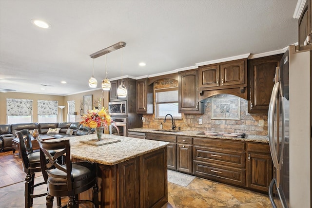 kitchen with stainless steel appliances, backsplash, a center island, pendant lighting, and sink