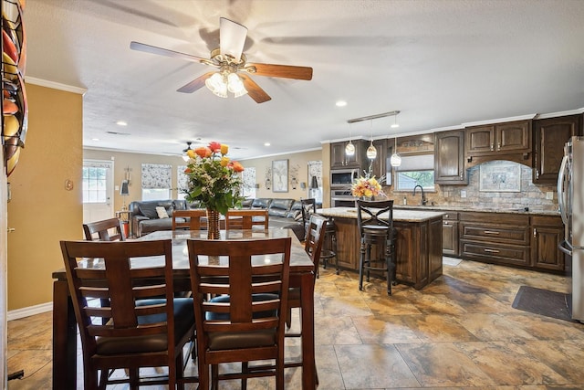 dining room with ceiling fan, track lighting, ornamental molding, and a textured ceiling