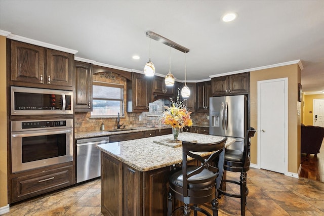 kitchen featuring a kitchen island, sink, dark brown cabinetry, stainless steel appliances, and light stone counters