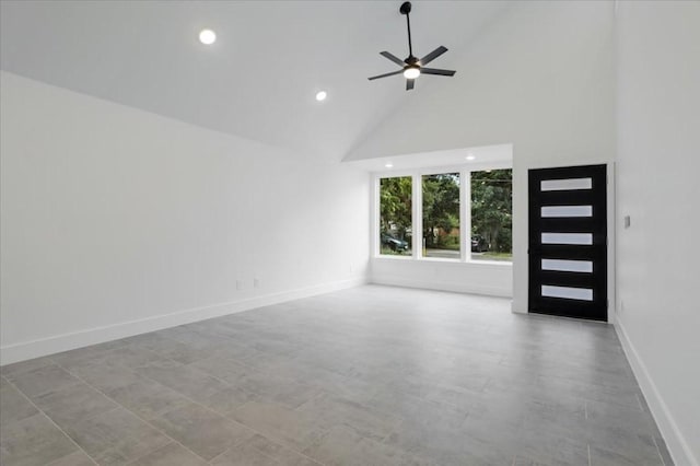 unfurnished living room with ceiling fan and high vaulted ceiling