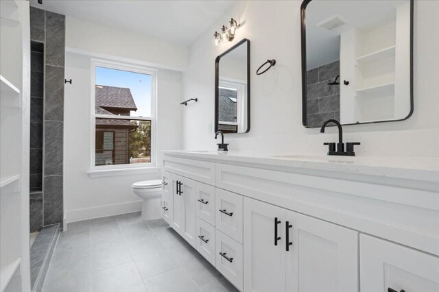 bathroom featuring tile patterned flooring, vanity, and toilet