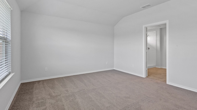 empty room featuring lofted ceiling and carpet