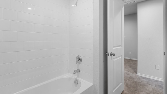 bathroom with tiled shower / bath and tile patterned floors