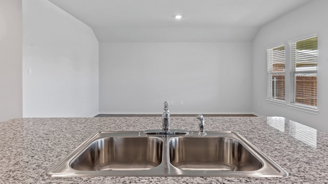 kitchen featuring lofted ceiling and sink