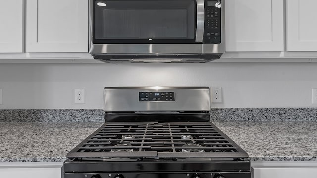 details featuring white cabinets, appliances with stainless steel finishes, and light stone countertops