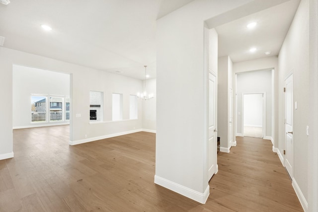 hall with hardwood / wood-style flooring and an inviting chandelier