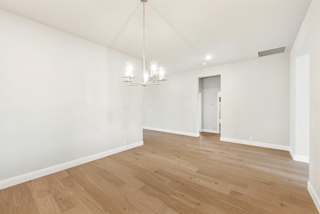 unfurnished dining area with a chandelier and light wood-type flooring