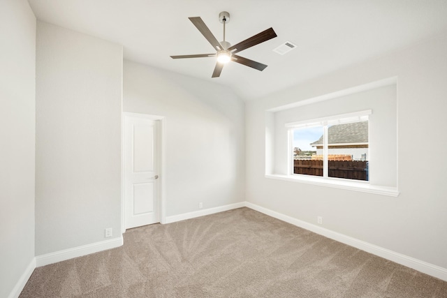 carpeted spare room featuring ceiling fan and lofted ceiling