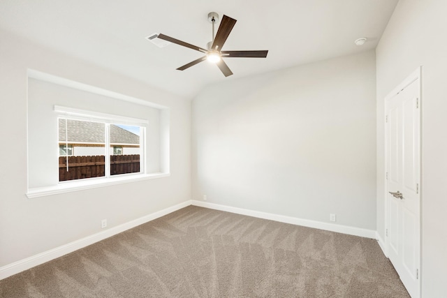 carpeted spare room featuring ceiling fan and vaulted ceiling