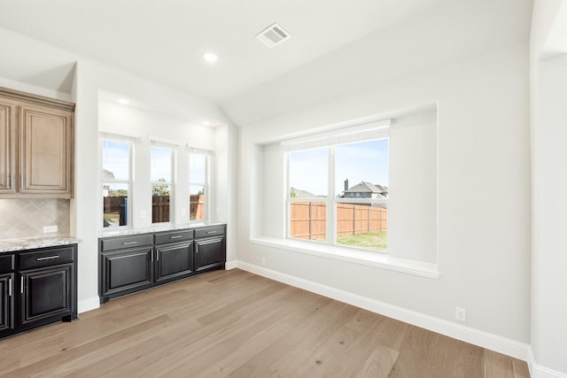 interior space with light hardwood / wood-style flooring and vaulted ceiling