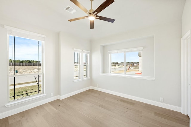 empty room with ceiling fan and light hardwood / wood-style flooring