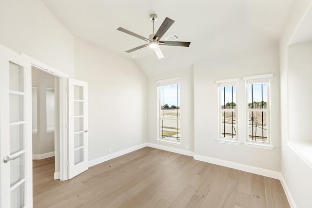 empty room with french doors, ceiling fan, vaulted ceiling, and light hardwood / wood-style floors