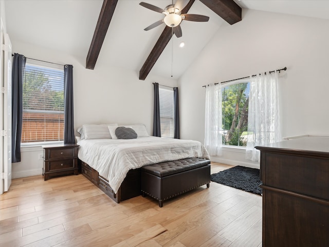 bedroom with light hardwood / wood-style flooring, ceiling fan, vaulted ceiling with beams, and multiple windows