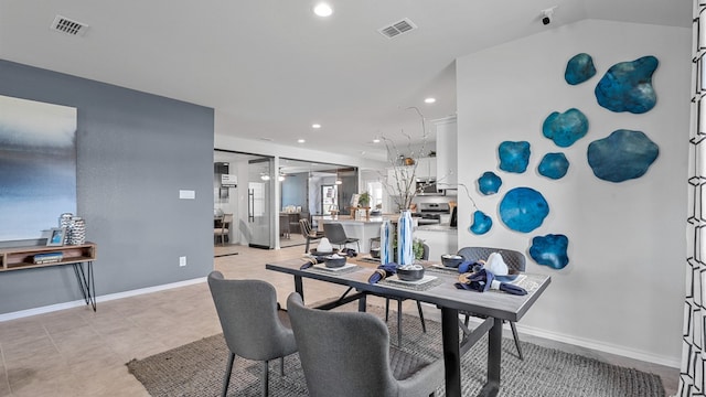 dining area featuring vaulted ceiling and light tile patterned floors