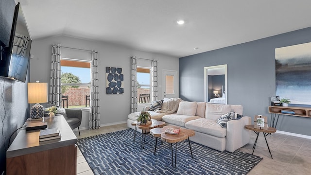 living room featuring plenty of natural light, vaulted ceiling, and light tile patterned floors