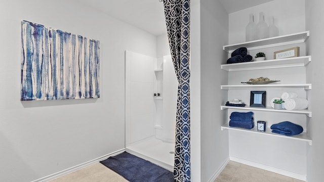 bathroom with a shower and tile patterned flooring