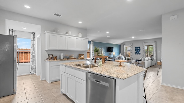 kitchen featuring light tile patterned floors, an island with sink, stainless steel appliances, sink, and white cabinetry