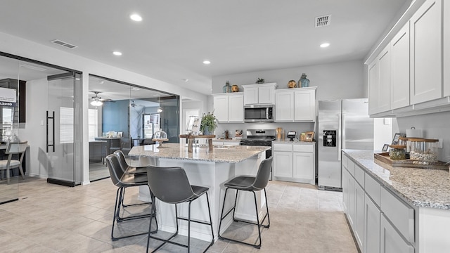 kitchen with white cabinetry, an island with sink, and stainless steel appliances