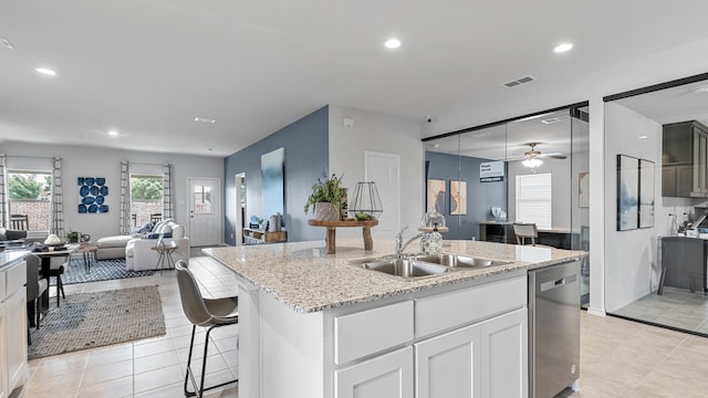 kitchen with white cabinets, sink, ceiling fan, a center island with sink, and stainless steel dishwasher