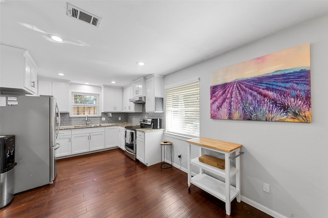 kitchen featuring appliances with stainless steel finishes, dark hardwood / wood-style flooring, plenty of natural light, and white cabinets