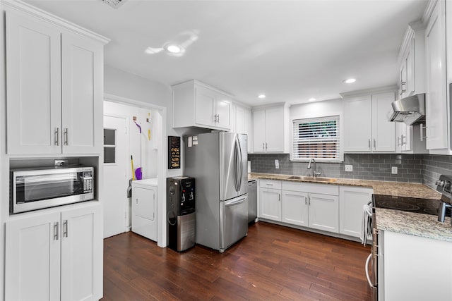 kitchen featuring stainless steel appliances, dark hardwood / wood-style flooring, ventilation hood, white cabinets, and washer / clothes dryer