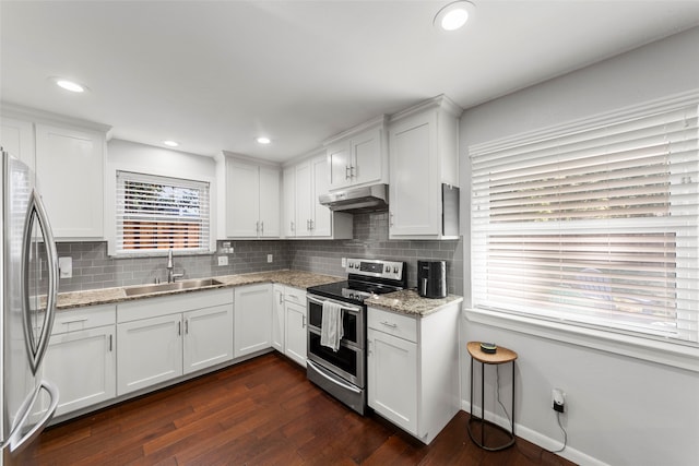 kitchen featuring white cabinetry, dark hardwood / wood-style flooring, sink, light stone countertops, and appliances with stainless steel finishes