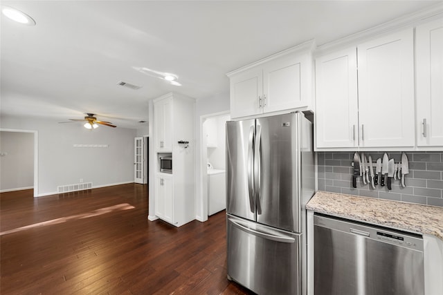 kitchen with light stone countertops, appliances with stainless steel finishes, dark wood-type flooring, white cabinetry, and ceiling fan