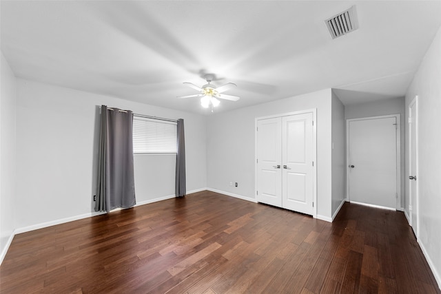 unfurnished bedroom featuring a closet, ceiling fan, and dark hardwood / wood-style floors