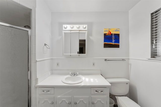 bathroom featuring vanity, toilet, and a shower with shower door