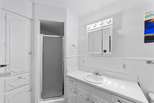 bathroom featuring a shower with shower door, toilet, and vanity