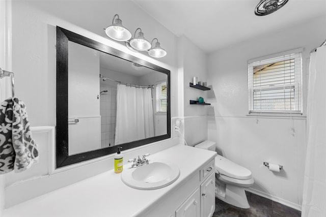 bathroom with walk in shower, toilet, plenty of natural light, and vanity