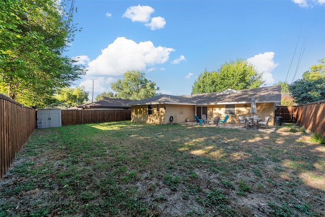 view of yard featuring a storage unit and a patio