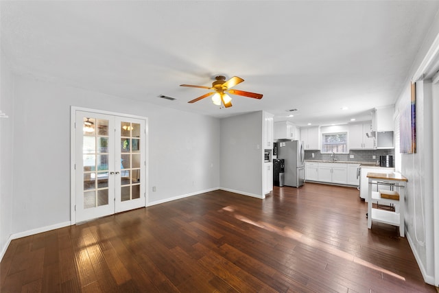 unfurnished living room featuring dark wood-type flooring, ceiling fan, sink, and french doors