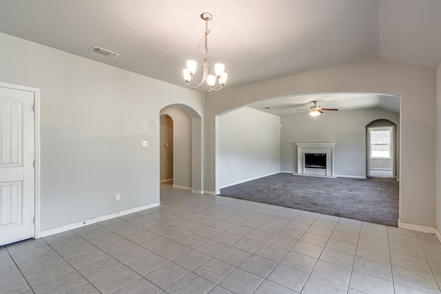 unfurnished living room featuring light colored carpet, vaulted ceiling, and ceiling fan with notable chandelier