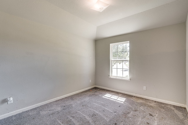 empty room with lofted ceiling, a textured ceiling, and carpet floors