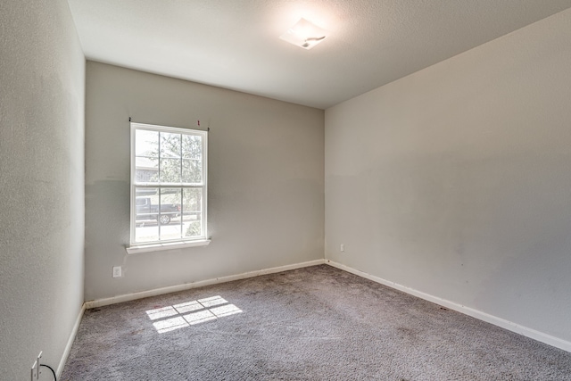 carpeted empty room with a textured ceiling