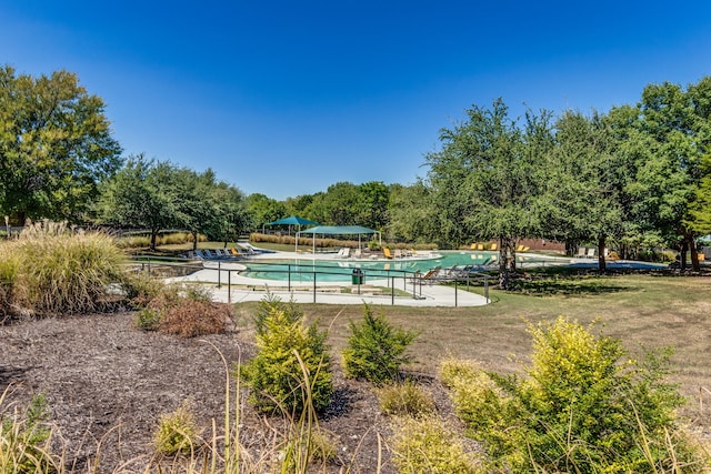 view of swimming pool featuring a yard