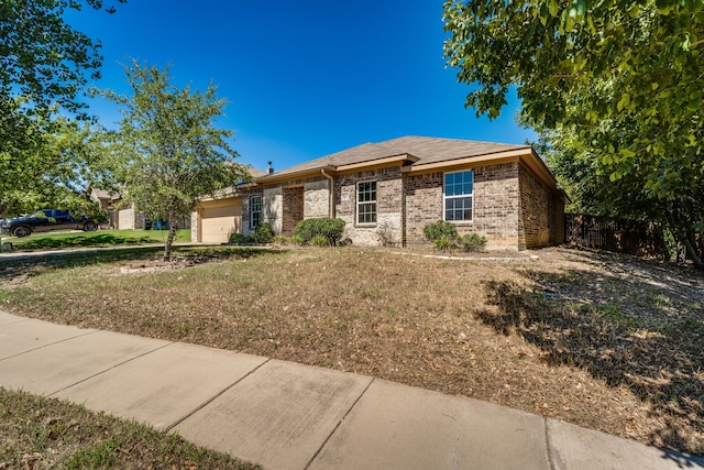 ranch-style house with a garage and a front lawn