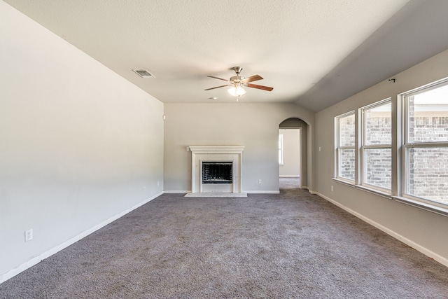 unfurnished living room with a textured ceiling, lofted ceiling, ceiling fan, and carpet floors