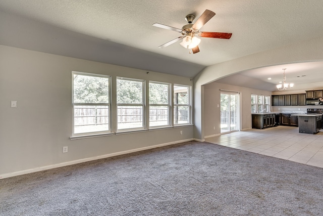 unfurnished living room with lofted ceiling, light colored carpet, ceiling fan with notable chandelier, and a textured ceiling