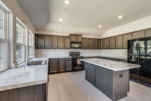 kitchen featuring light tile patterned floors, black appliances, a kitchen island, sink, and lofted ceiling