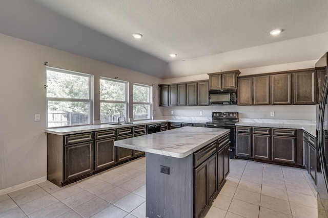 kitchen featuring plenty of natural light, black appliances, light tile patterned flooring, and a kitchen island