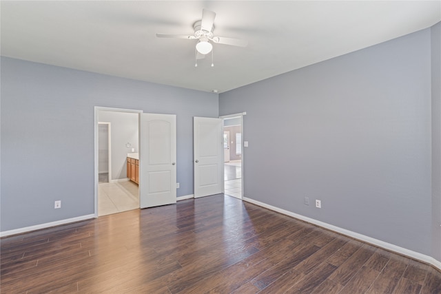 unfurnished bedroom featuring ceiling fan, ensuite bath, and dark hardwood / wood-style flooring