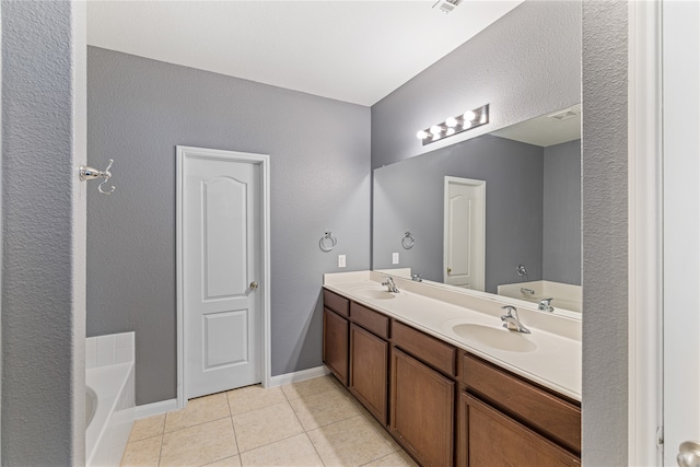 bathroom featuring a bathing tub, vanity, and tile patterned floors