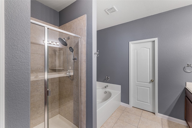 bathroom featuring vanity, a textured ceiling, tile patterned floors, and plus walk in shower