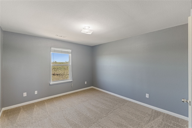 spare room featuring carpet and a textured ceiling