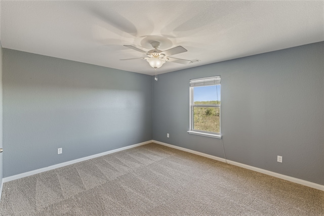 empty room featuring ceiling fan and carpet