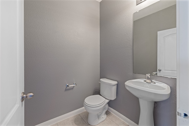 bathroom with toilet and tile patterned flooring