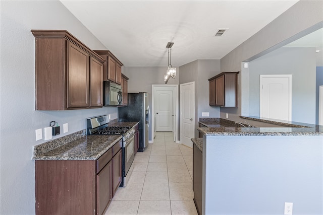 kitchen with stainless steel appliances, dark stone counters, kitchen peninsula, light tile patterned floors, and pendant lighting